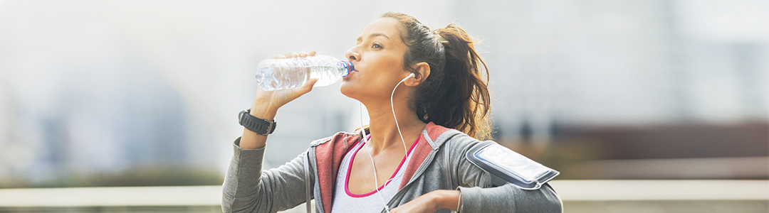 Eine Frau auf einer Bank die Wasser trinkt