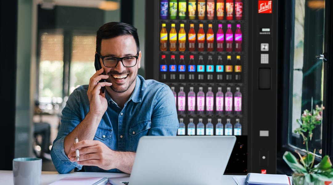 Ein Mann der am Laptop Arbeitet vor einem Automaten